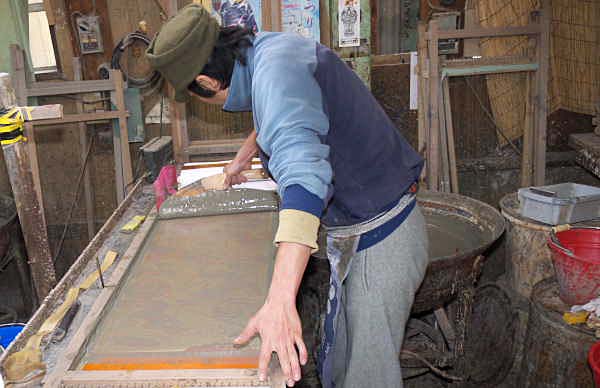 ヘラで反物に防染糊